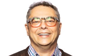 A smiling portrait of AWS Chief Medical Officer Taha Kass-Hout